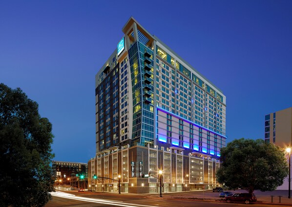 A multi-story hotel with a modern glass facade, large windows, and a prominent 'AC' sign. - Residence Inn Nashville Downtown (Nashville)