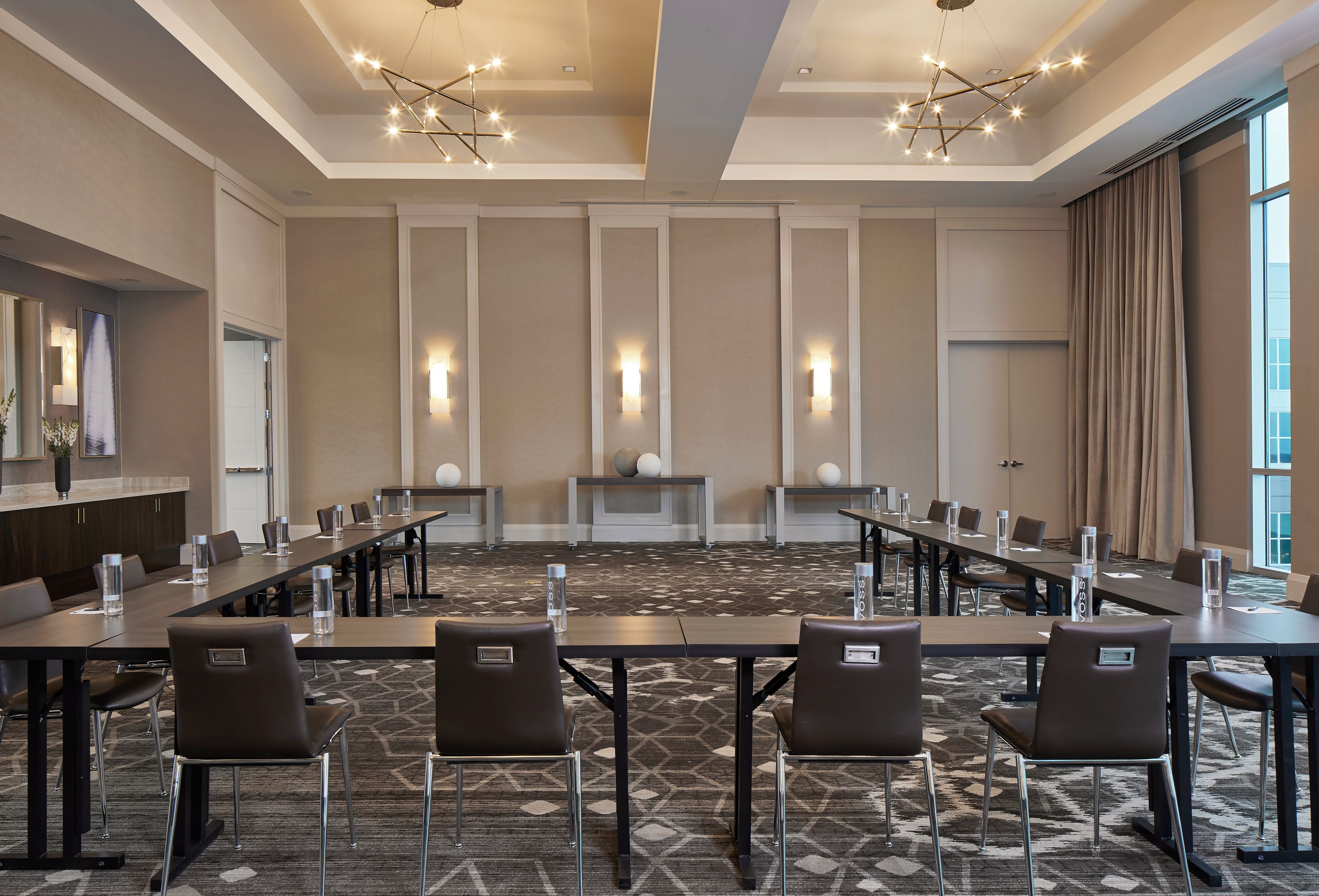 A conference room with a long table, chairs, and a carpeted floor.