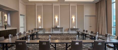 A conference room with a long table, chairs, and a carpeted floor.