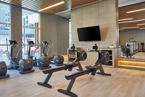 A gym with various exercise equipment, a large TV on the wall, and a view of the outside through large windows. - Residence Inn Nashville Downtown (Nashville)