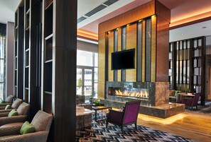 A modern lobby with a fireplace, comfortable seating, and a flat-screen TV. - Residence Inn Nashville Downtown (Nashville)