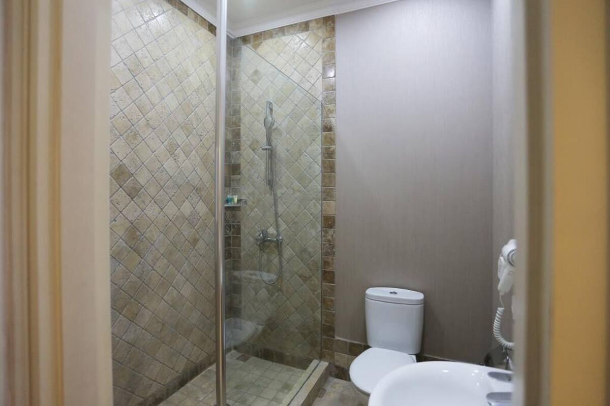 Un baño con ducha de vidrio, inodoro y lavabo.