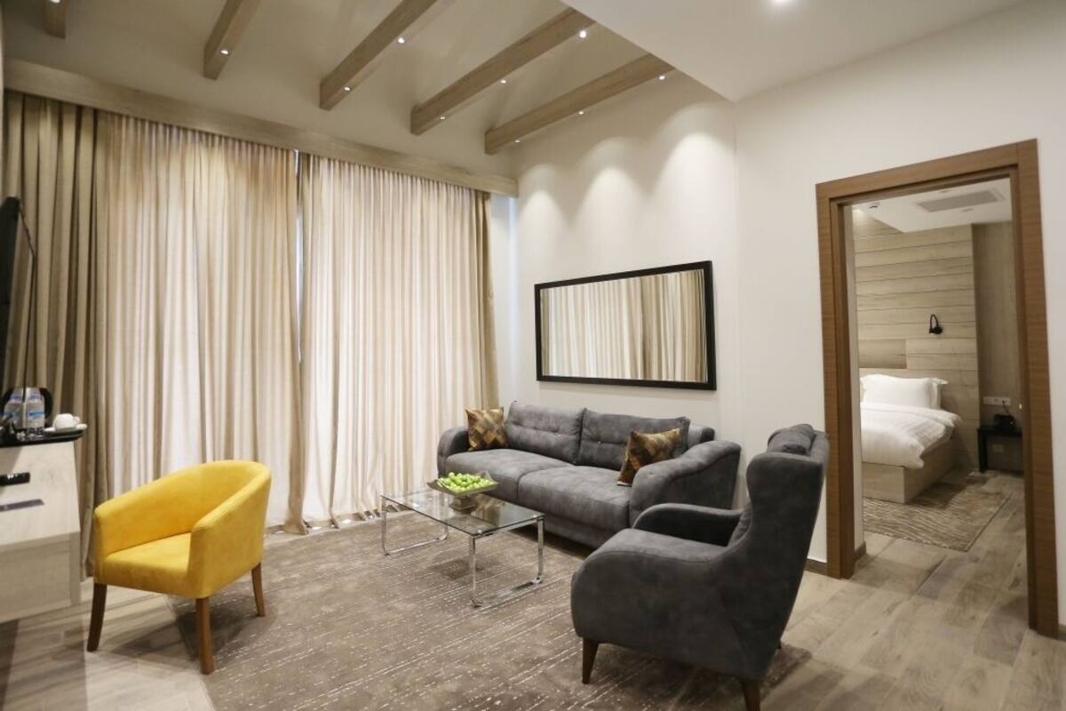 Una sala de estar moderna con un sofá, sillones, una mesa de centro y un televisor.