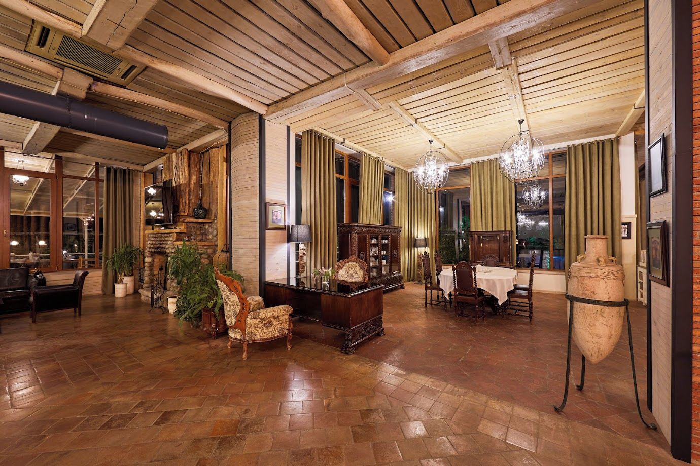 Un vestíbulo espacioso con pisos de madera, una chimenea y un comedor con candelabro.