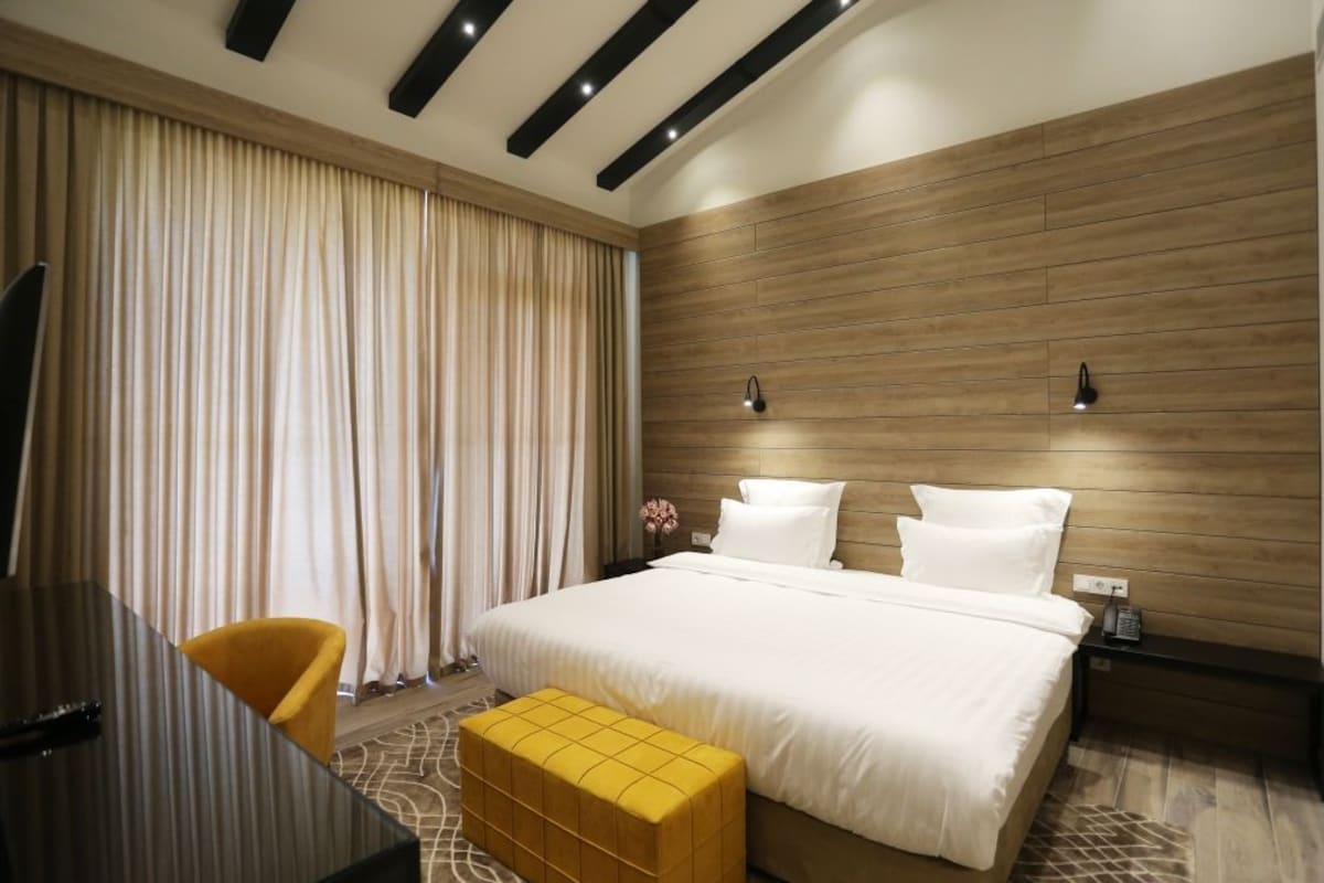 Una habitación de hotel moderna con una cama grande, un escritorio y una silla.