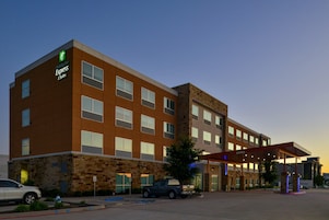 Un hotel Holiday Inn Express con fachada de piedra, múltiples ventanas y entrada cubierta.