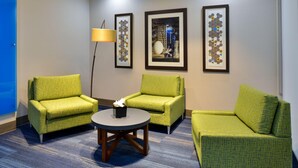 A hotel room with two green armchairs, a small round table, and three framed artworks on the wall. - Holiday Inn Express and Suites Wylie West (Wylie)