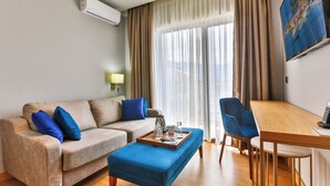 A living room with a sofa, ottoman, and dining table. - Lusso Mare (Boreti)