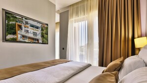 A hotel room with a bed, a window with curtains, and a framed picture on the wall. - Lusso Mare (Boreti)