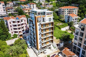 A multi-story hotel with balconies, a rooftop terrace, and a sign reading "Lusso Mare".