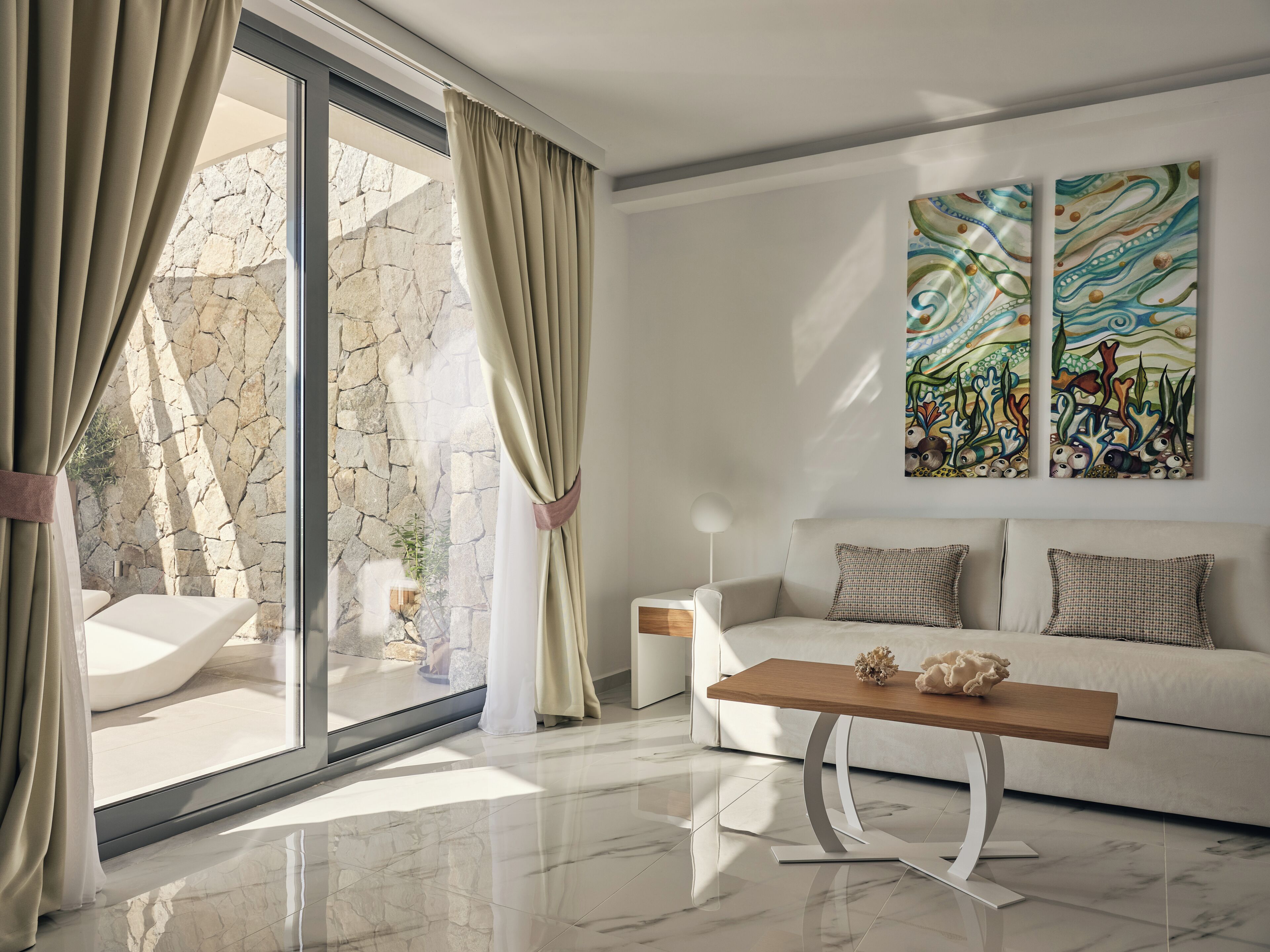 A modern living room with a sofa, a wooden coffee table, and a large window with curtains.