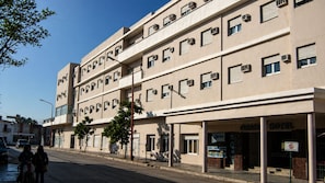 A multi-story hotel with a flat facade, air conditioning units, and a sign indicating 'GRAN HOTEL.'