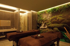 A spa room with two massage tables, a sink, and a wall mural of a waterfall. - Secrets Sunny Beach Resort & Spa (Nessebar)