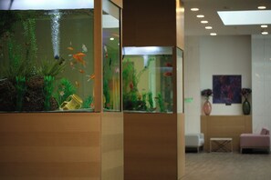 A reception area with a large aquarium, seating, and a painting on the wall. - Secrets Sunny Beach Resort & Spa (Nessebar)