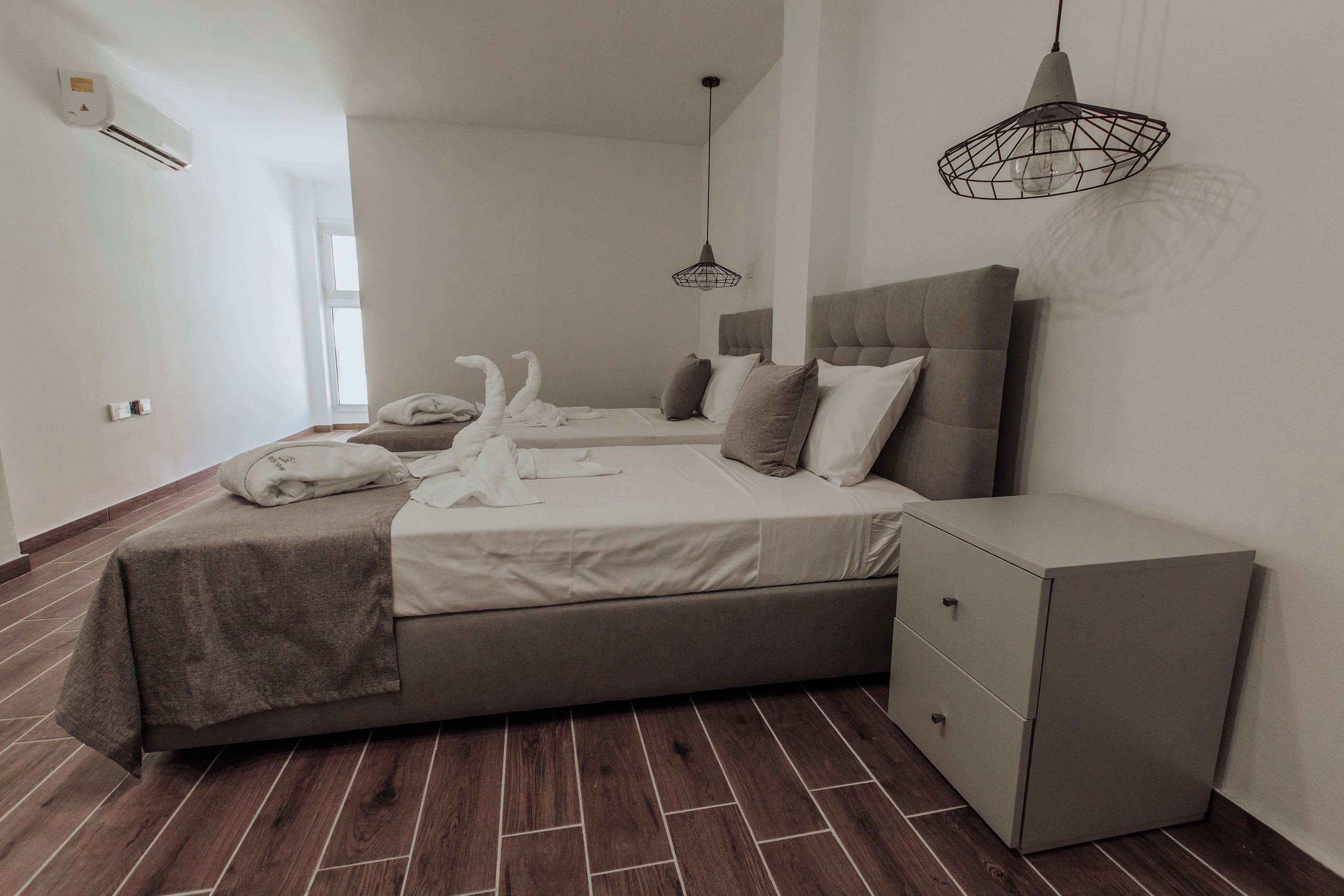Ein modernes Schlafzimmer mit einem Bett, Nachttischen und einem Kleiderschrank.