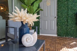 A table with a vase of dried flowers, a decorative shell, and a potted plant. - Palm Luxe at Captiva •Heated pool•BBQ• (Davenport)