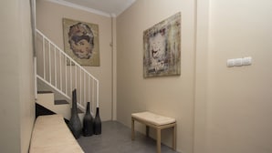 A hallway with a bench, a small table, and two vases. - Irooms (Ngaglik)