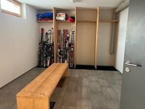 Ein Skiraum mit einer Holzbank und Skiern.