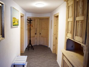 A hallway with wooden doors, a coat rack, and a bench. - Gyrgarta, Obersaxen-Meierhof, (Obersaxen), 34066B by Interhome (Obersaxen Affeier)