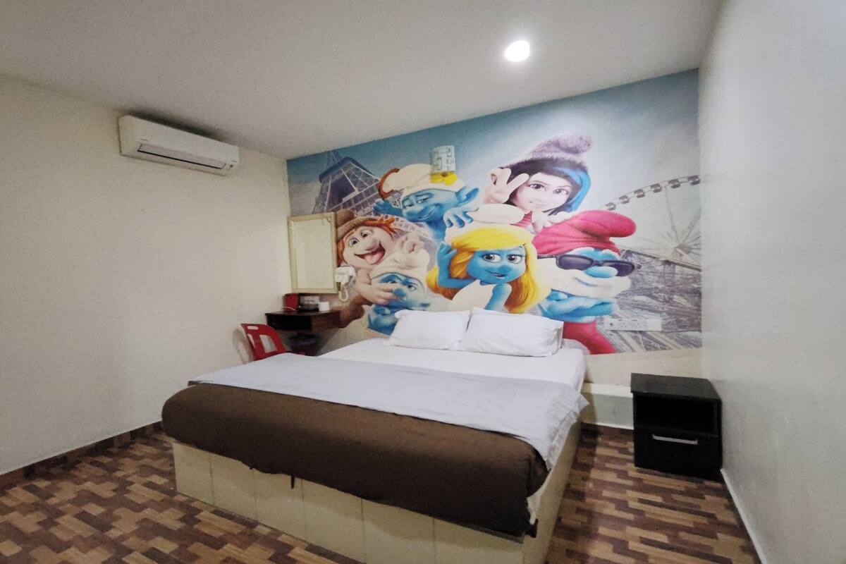 A hotel room with a bed, a wall mural, an air conditioning unit, a nightstand, and a speaker.