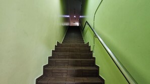 A staircase with wooden steps and green walls, leading to a higher floor. - Nova Hotel Ipoh by Zuzu (Ipoh)
