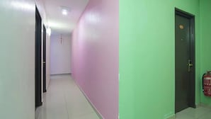 A hallway with a door, a fire extinguisher, and a tiled floor. - Nova Hotel Ipoh by Zuzu (Ipoh)