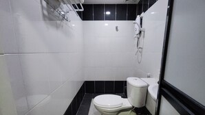 A small, compact bathroom with a white toilet, a sink, and a shower. - Nova Hotel Ipoh by Zuzu (Ipoh)