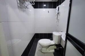 A small, compact bathroom with a white toilet, a sink, and a shower. - Nova Hotel Ipoh by Zuzu (Ipoh)