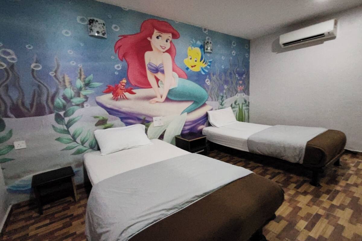 A room with two beds, a mural of a mermaid, and an air conditioning unit.