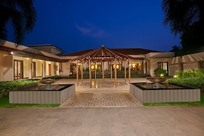 A modern building with a central pavilion, a water feature, and a well-maintained garden.