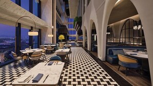 A modern hotel lobby with a checkered floor, seating areas, and large windows offering a city view. - Fairmont Xiamen (Xiamen)