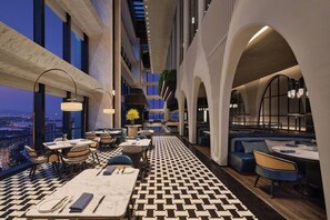 A modern hotel lobby with a checkered floor, seating areas, and large windows offering a city view. - Fairmont Xiamen (Xiamen)