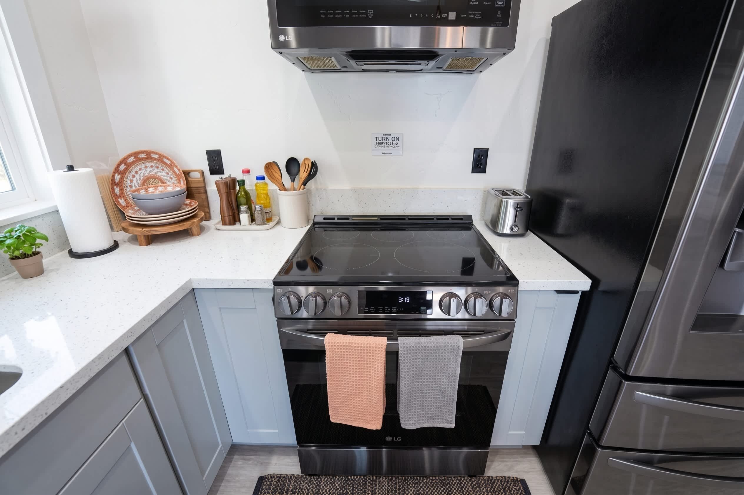 A modern kitchen with a built-in stove, oven, and a stainless steel refrigerator.