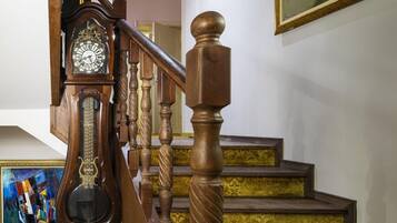 A staircase with wooden balusters and a clock on the left.