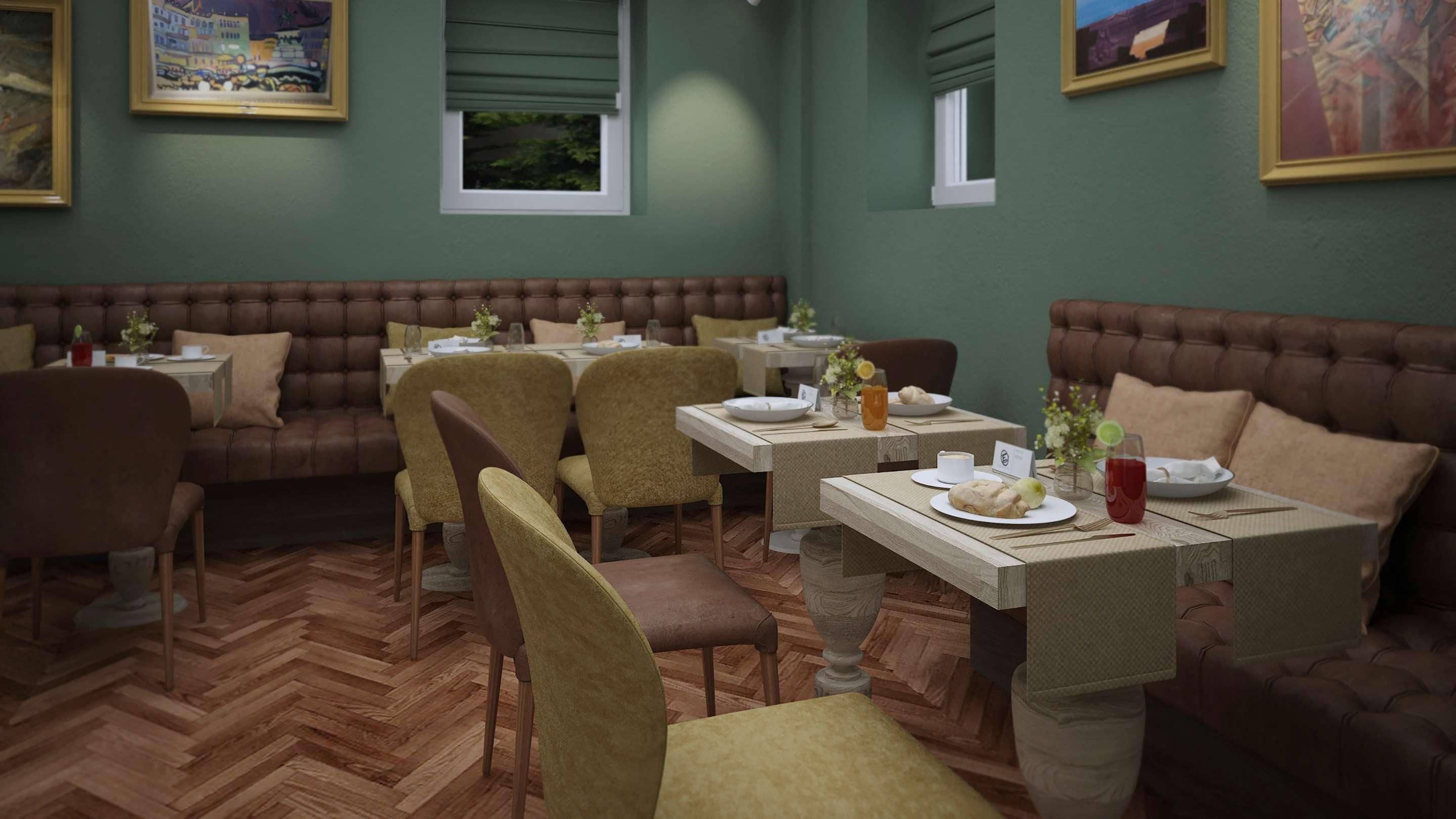 A restaurant with booths and tables, wooden herringbone flooring, and green walls.