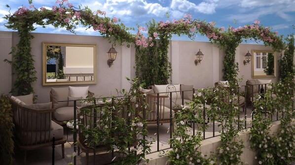 An outdoor seating area with cushioned chairs, a table, and a pergola covered with flowering vines. - Gallery 37, BW Premier Collection (Plovdiv)