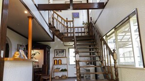 Una escalera de madera con barandilla que conduce a un piso superior.