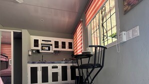A kitchen with white cabinets, a marble countertop, and a dining area with a table and chairs.