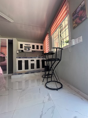 A kitchen with white cabinets, a marble countertop, and a dining area with a table and chairs. - 6/separate villa/picina /Jacuzzy and more (Paya)