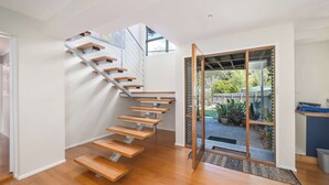 Ein modernes Interieur mit einer Holztreppe zu einem Balkon.