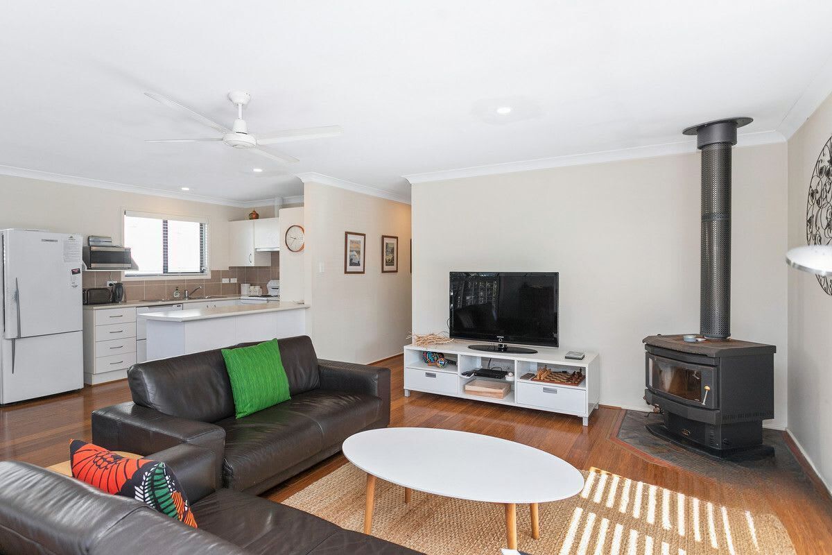A modern living room with a sofa, TV, and fireplace.