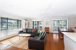 Ein geräumiges Wohnzimmer mit Sofa, Couchtisch und Essbereich.