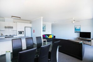 A modern hotel room with a kitchen, dining area, and living space. - Fathoms 19 at Mollymook (Mollymook Beach)