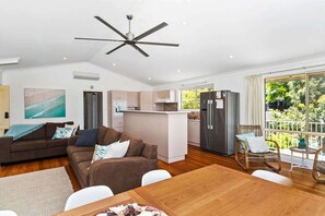Ein stilvoller Wohnraum mit Sofa, Esstisch, Küchenzeile und einem Balkon mit Blick.