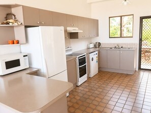A compact kitchen with a refrigerator, microwave, oven, and dishwasher. - Ocean Front on Malibu (Bawley Point)