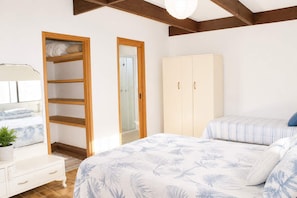 Un dormitorio con cama, armario, mesita de noche y espejo.