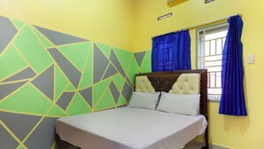 A bed with a headboard, a window with blue curtains, and a geometric wall design. - Life Lavenia Kost 2 (Dumai)