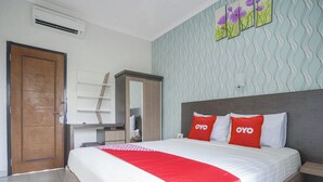 Un dormitorio con cama, armario, escritorio y puerta.