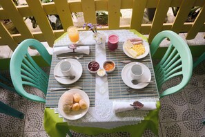 A table set with plates, bowls, cutlery, and a placemat. - VOA Pousada Dos Jasmins (Serra)