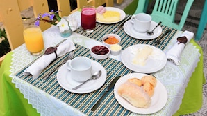 Una mesa lista para el desayuno, con platos de comida, un vaso de jugo y una taza de café.